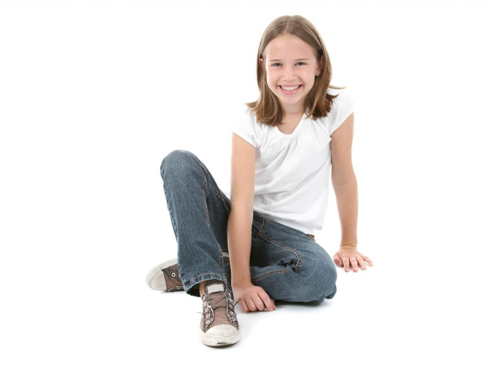 young girl in jeans and white t-shirt sitting on the floor